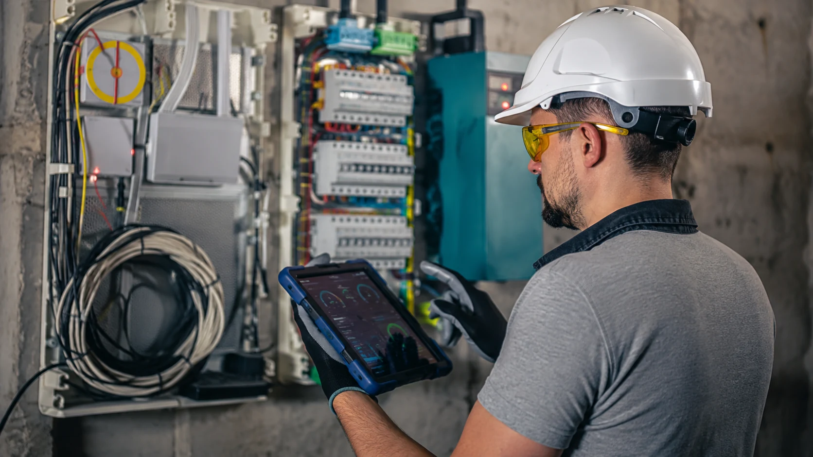 Especialista supervisando una instalación eléctrica con una tableta